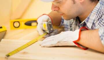 Worker measuring wood board